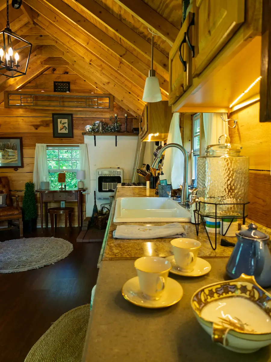 The Bridal Suite kitchen counter with teacups, a glass beverage dispenser, and a farmhouse sink