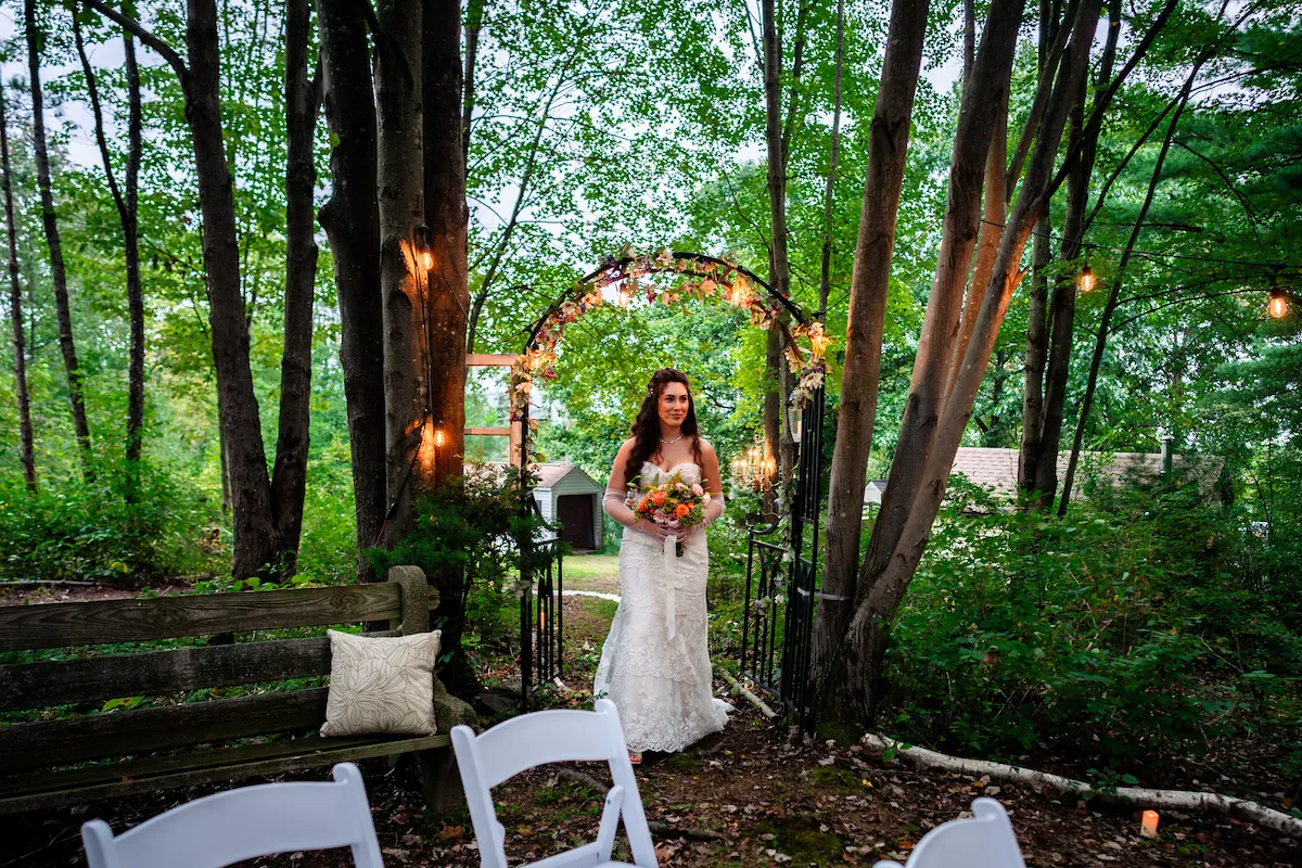 Naomi waits at the garden arch before walking down the aisle