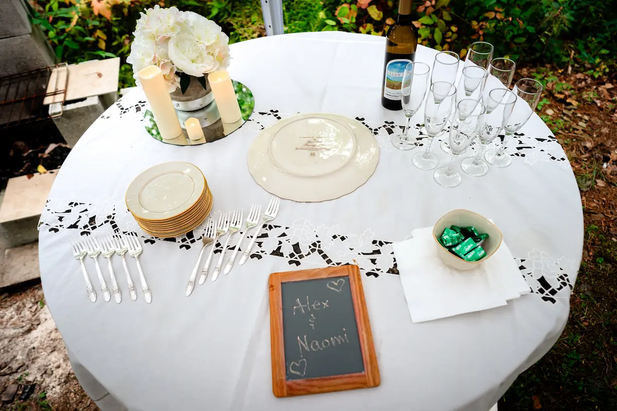 The cake table set with candles, flowers, and a chalkboard reading Alex and Naomi
