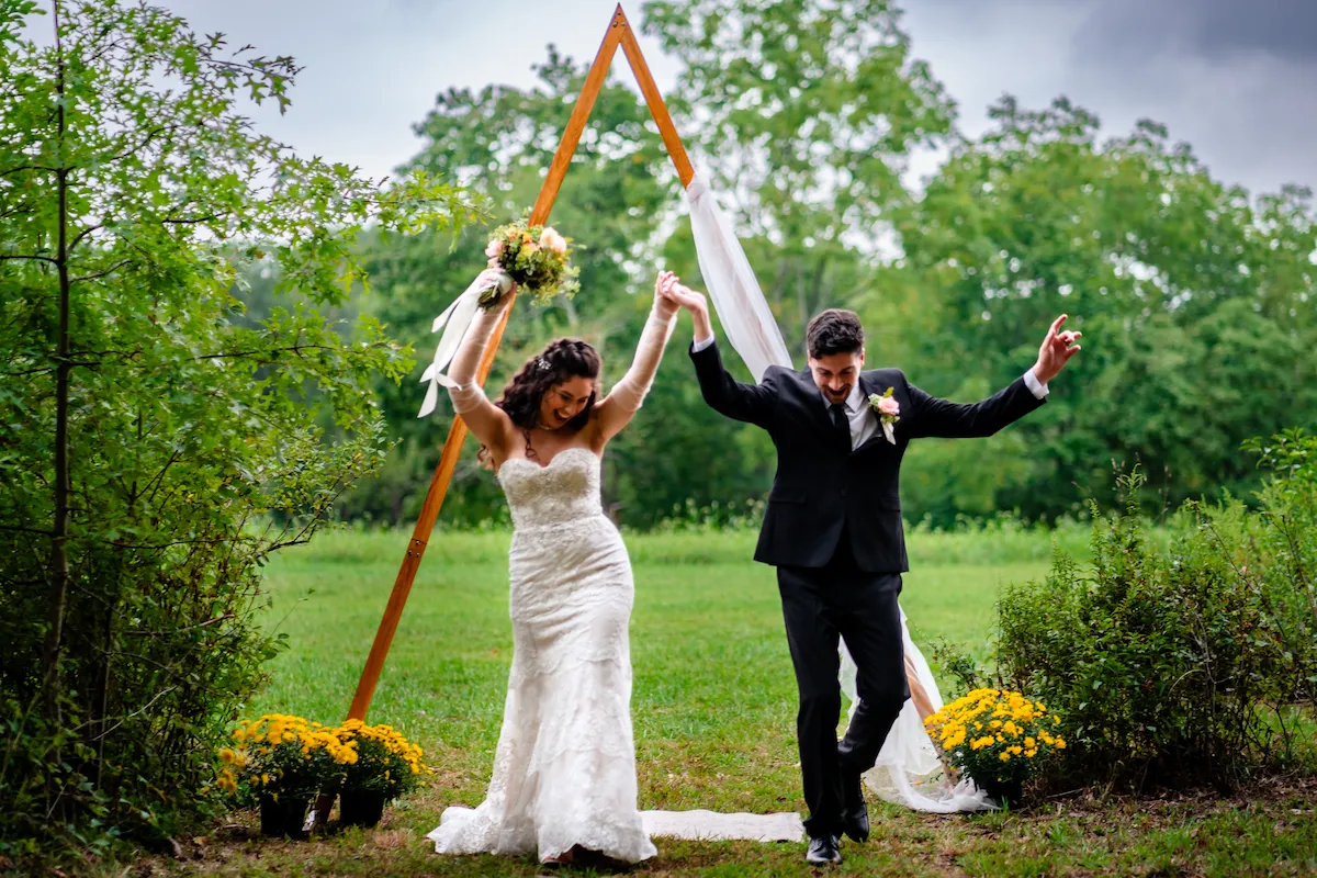 Alex and Naomi throw their hands up in celebration after the ceremony