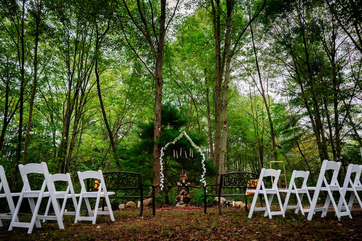 The chapel set with white chairs and the flower-wound arch before the ceremony