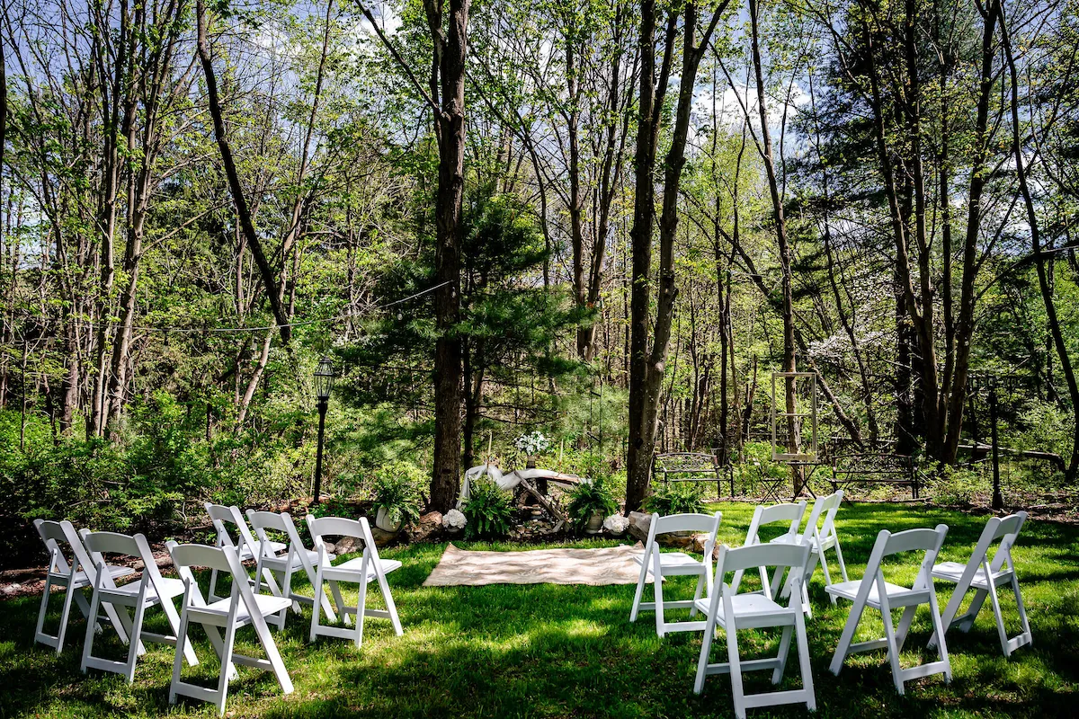 The chapel set with white chairs in the spring woods before the ceremony